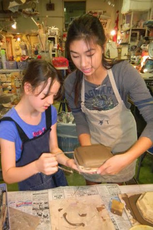 Mai (12) assisting a 5th grader with making her plate. 