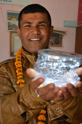 Shyam Basnet, Headmaster of Shree Manakamana Primary School holds a Luci Light in his hands. His school, along with thousands of other schools in Nepal, is currently faced with damage due to the quake.