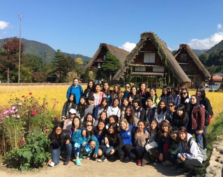 The junior class in front of the Gassho - zukuri farmhouses in Shirakawa -go. 