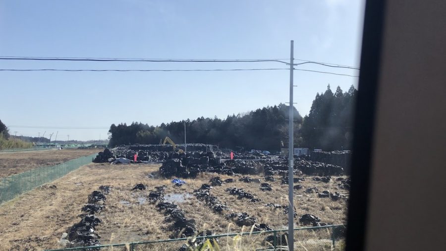 Radioactive soil is packed into black plastic bags. 